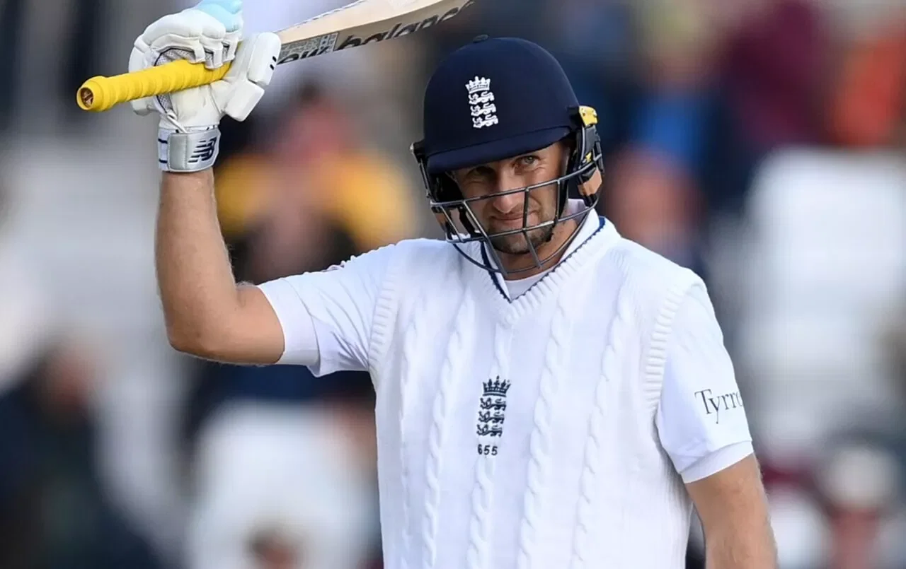 Joe Root raises his bat after completing 13,000 test runs
